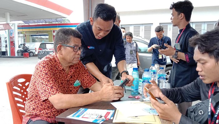 Warga di Manado dilayani registrasi aplikasi MyPertamina untuk isi BBM.