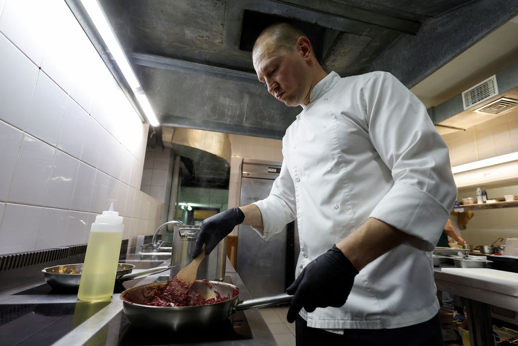 Koki Ukraina Yevhenii Marshal memasak borshch di restoran masakan tradisional, saat serangan Rusia di Ukraina berlanjut, di Kyiv, Ukraina, Jumat (1/7/2022). (REUTERS/Valentyn Ogirenko)