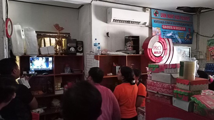 Petugas kepolisian dan staf UKM Mart KUD Pejaten, Tabanan, Bali, mengamati rekaman CCTV. Plafon di pojok kanan atas terlihat berlubang diduga dibobol maling, Sabtu (2/7/2022).