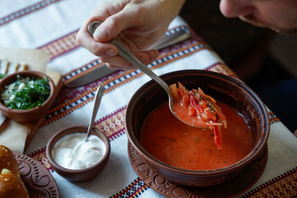 Seorang pria makan borshch hidangan Ukraina di restoran masakan tradisional, saat serangan Rusia di Ukraina berlanjut, di Kyiv, Ukraina, Jumat (1/7/2022). (REUTERS/Valentyn Ogirenko)