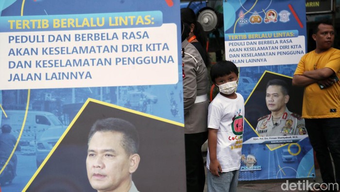 Petugas dari Polantas Polda Metro Jaya memberikan sosialisasi Berkendara Dengan Aman di kawasan Car Free Day, Bundara HI, Jakarta Pusat, Minggu (3/7). Kegiatan ini bertujuan memberikan edukasi kepada warga tentang kampanye aman  berkendara.