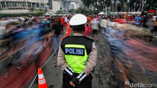 Petugas dari Polantas Polda Metro Jaya memberikan sosialisasi Berkendara Dengan Aman di kawasan Car Free Day, Bundara HI, Jakarta Pusat, Minggu (3/7). Kegiatan ini bertujuan memberikan edukasi kepada warga tentang kampanye aman  berkendara.