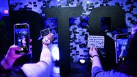 Penggemar K-pop mengambil gambar catatan mereka yang tertulis di stiker untuk dipasang di dinding saat mereka mengunjungi toko pop-up BTS. Patrick T. Fallon/AFP via Getty Images
