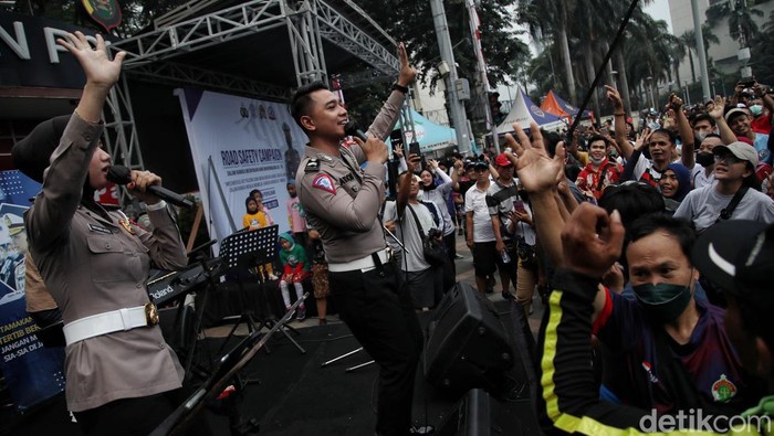 Momen Warga Asyik Bernyanyi dan Berjoget Bareng Cakra Metro Band di CFD Jakarta Cakra Metro Band yang digawangi para anggota Polri ikut memeriahkan HUT Bhayangkara di CFD Bundaran HI, Jakarta. Warga nampak antusias ikut berjoget dan bernyanyi, Minggu, 3/7/2022.