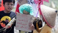 Sejumlah anak memasang karton berisi tulisan harapan pada orang-orangan sawah berbahan jerami dalam Festival Anak Sawah di kawasan persawahan Kampung Lali Gadget (KLG), Desa Pagerngumbuk, Wonoayu, Sidoarjo, Jawa Timur, Minggu (3/7/2022).