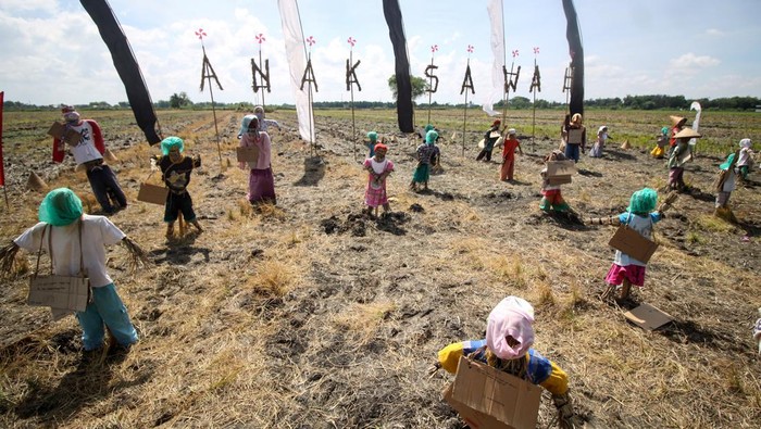 Potret Festival Anak Sawah di Sidoarjo Sejumlah anak memasang karton berisi tulisan harapan pada sebuah orang-orangan sawah berbahan jerami dalam Festival Anak Sawah di kawasan persawahan Kampung Lali Gadget (KLG), Desa Pagerngumbuk, Wonoayu, Sidoarjo, Jawa Timur, Minggu (3/7/2022). Festival Anak Sawah yang diikuti oleh puluhan siswa tersebut selain memperingati Hari Anak Nasional 2022, juga untuk hiburan yang bertujuan untuk mengasah dan menyalurkan kreatifitas anak. ANTARA FOTO/Umarul Faruq/nym.