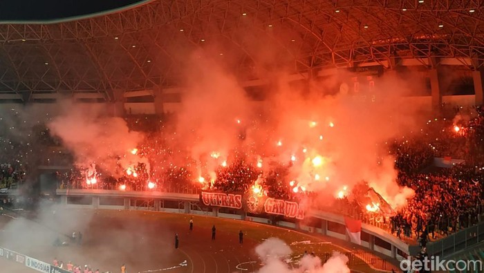 Suporter Timnas Indonesia menyalakan flare di laga Indonesia vs Vietnam di Piala AFF U-19 2022