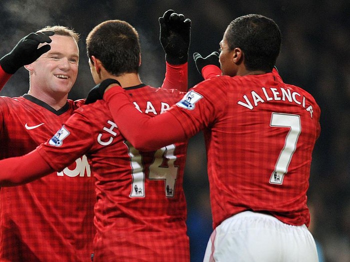 Manchester United's English striker Wayne Rooney (L) celebrates scoring the opening goal with Ecuadorian midfielder Antonio Valencia (R) and Mexican striker Javier Hernandez (2nd L) during the English FA Cup third round replay football match between Manchester United and West Ham United at Old Trafford, Manchester, North West England on January 16, 2013. AFP PHOTO/PAUL ELLIS

RESTRICTED TO EDITORIAL USE. No use with unauthorized audio, video, data, fixture lists, club/league logos or “live” services. Online in-match use limited to 45 images, no video emulation. No use in betting, games or single club/league/player publications.        (Photo credit should read PAUL ELLIS/AFP via Getty Images)