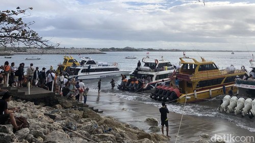 Para penumpang naik dan turun kapal langsung di bibir Pantai Sanur, Bali, Sabtu (2/7/2022). Pemandangan ini terlihat karena pelabuhan masih dalam proses pembangunan. Pelabuhan Sanur diperkirakan selesai pada September 2022.