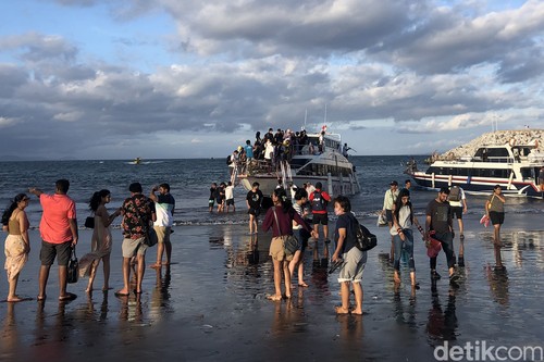 Para penumpang naik dan turun kapal langsung di bibir Pantai Sanur, Bali, Sabtu (2/7/2022). Pemandangan ini terlihat karena pelabuhan masih dalam proses pembangunan. Pelabuhan Sanur diperkirakan selesai pada September 2022.