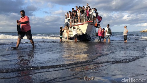 Para penumpang naik dan turun kapal langsung di bibir Pantai Sanur, Bali, Sabtu (2/7/2022). Pemandangan ini terlihat karena pelabuhan masih dalam proses pembangunan. Pelabuhan Sanur diperkirakan selesai pada September 2022.