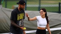 Tidak hanya bermain tenis, sesekali mereka juga bersenda-gurau di tengah lapangan.