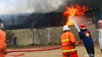 Petugas berjibaku memadamkan kebakaran melanda pabrik minyak kelapa, PT Indo Oil Perkasa di Jetis, Mojokerto, Senin (4/7/2022) siang/Foto: Enggran Eko Budianto/detikJatim