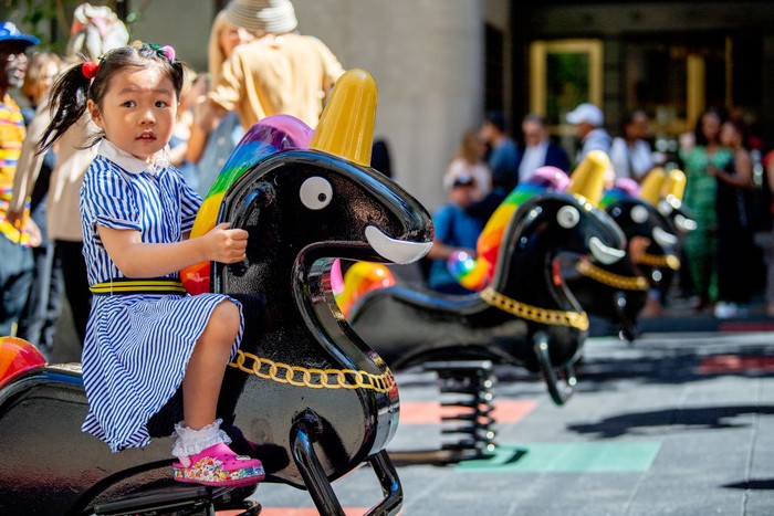 NEW YORK, NEW YORK - JUNE 29: A child plays on artist Derrick Adams's newly installed Funtime Unicorns at the Channel Garden in Rockefeller Center on June 29, 2022 in New York City. The Funtime Unicorns installation will be in Rockefeller Center until September 9th. (Photo by Roy Rochlin/Getty Images)