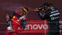 Pembalap Ferrari Carlos Sainz dari Spanyol (kiri) melakukan selebrasi dengan pebalap Mercedes urutan ketiga Lewis Hamilton dari Inggris di podium setelah memenangkan Grand Prix F1 Inggris di sirkuit Silverstone. (AP/Matt Dunham)