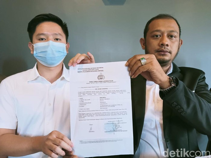 Erik dan kuasa hukumnya Arfan saat menunjukkan bukti laporan polisi. (Goklas/detikSumut)