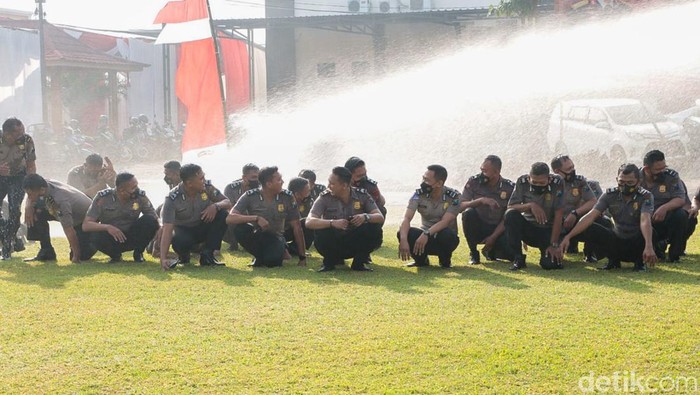 Puluhan personel Polres Jombang mandi dengan air watercanon untuk merayakan kenaikan pangkat