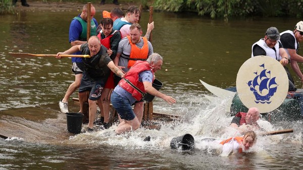 Seorang peserta jatuh ke dalam air saat perahu rakitnya diganggu lawan dalam perlombaan valap rakit Chester.