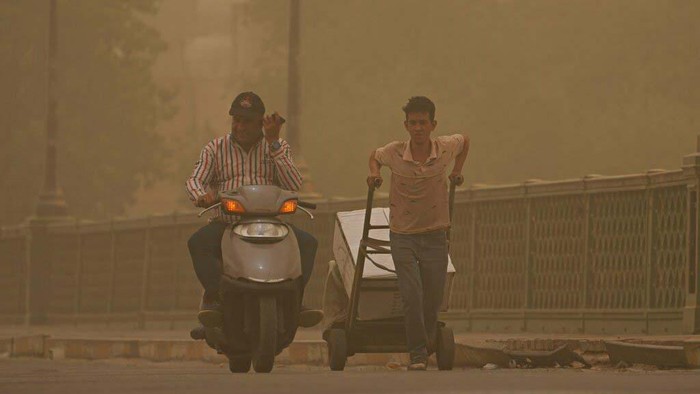 A man navigates his wheelchair on a street during a sandstorm in Baghdad, Iraq, Sunday, July 3, 2022. (AP Photo/Hadi Mizban)