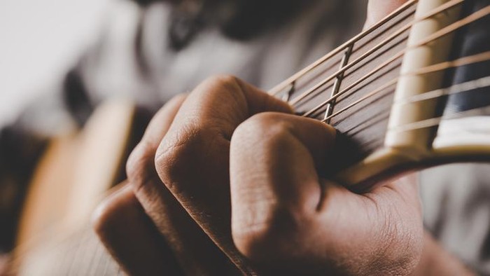 Close up of man hand playing guitar.