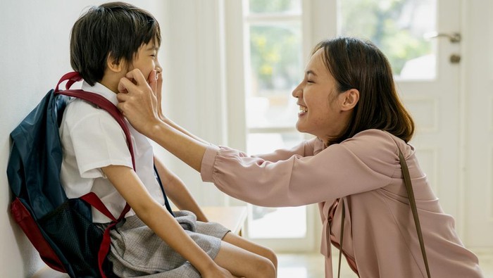Mother prepares to send her son to school.