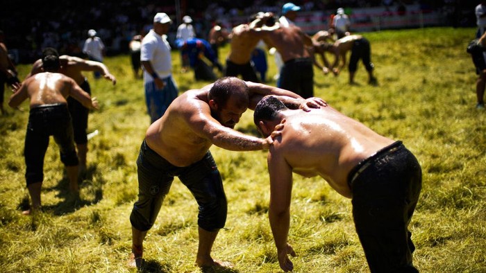 Wrestlers compete during the 661st annual Historic Kirkpinar Oil Wrestling championship, in Edirne, northwestern Turkey, Sunday, July 3, 2022. The festival is part of UNESCO's List of Intangible Cultural Heritages. (AP Photo/Francisco Seco)