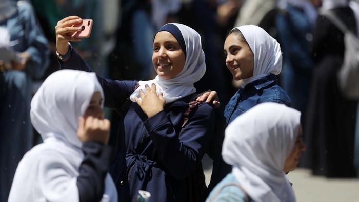 Begini Lho.. Cara Siswa Palestina Rayakan Kelulusan Palestinian students celebrate the last day in their final high school exams, known as ''Tawjihi'', in Gaza city on July 04, 2022. (Photo by Majdi Fathi/NurPhoto via Getty Images)