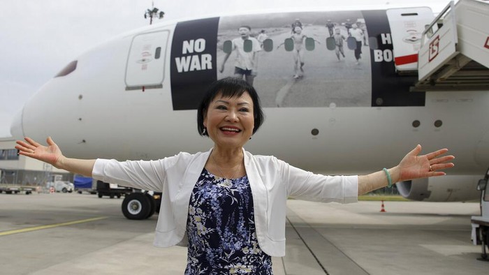 Kim Phuc, the girl in the famous 1972 Vietnam napalm attack photo, poses for a picture in front of a plane transporting refugees fleeing the war in Ukraine to Canada, from Frederic Chopin Airport in Warsaw, Poland, Monday, July 4, 2022. Phuc's iconic Associated Press photo in which she runs with her napalm-scalded body exposed, was etched on the private NGO plane that flew the refugees Monday to the city of Regina, the capital of the Canadian province of Saskatchewan. (AP Photo/Michal Dyjuk)