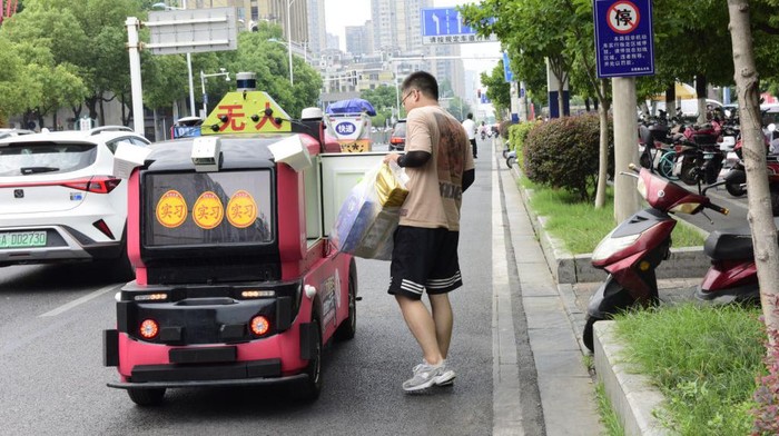 HEFEI, CHINA - JULY 5, 2022 - An unmanned delivery vehicle runs on a road in Hefei, East China's Anhui Province, July 5, 2022. The distribution area covers about 5 square kilometers. This is the first time for unmanned delivery vehicles to enter the distribution system of large chain supermarkets in Hefei and provide intelligent services for surrounding residents. (Photo credit should read CFOTO/Future Publishing via Getty Images)