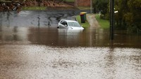 Sebuah mobil terendam banjir di kawasan permukiman warga di Windsor, Sydney, Australia. Reuters/Loren Elliott.