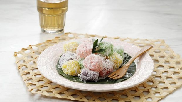 Ilustrasi Cenil Colorful Ongol Ongol or Sentiling, Steamed Cassava Cake Coating with Grated Coconut, Served on Ceramic Plate. Copy Space for Text