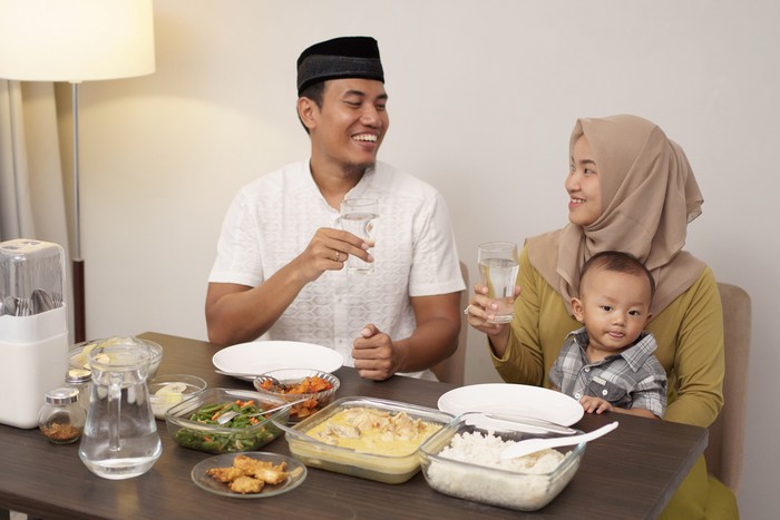 asian muslim family drink a glass of water for breaking the fast in the evening