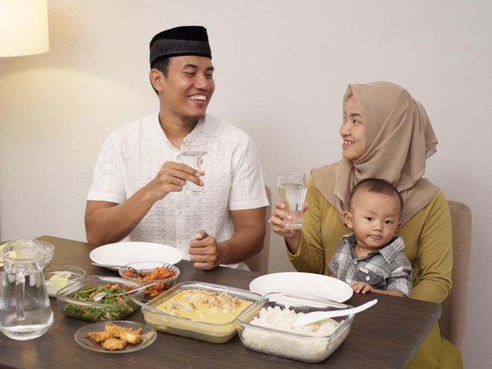 asian muslim family drink a glass of water for breaking the fast in the evening