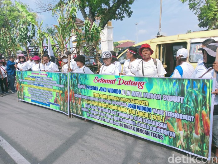 Kelompok massa menyambut kedatangan Presiden Jokowi di Jalan Brigjen Katamso, Medan. (Goklas/detikSumut)