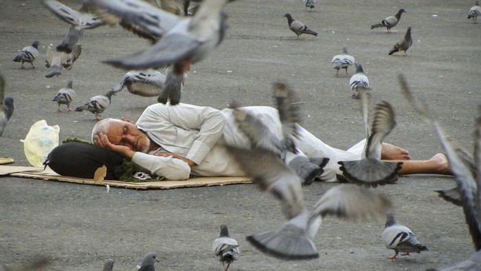 Pigeons surround pilgrims outside the the Grand Mosque in the Saudi Arabia's holy city of Mecca, Tuesday, July 5, 2022. Saudi Arabia is expected to receive one million Muslims to attend Hajj pilgrimage, which will begin on July 7, after two years of limiting the numbers because coronavirus pandemic. (AP Photo/Amr Nabil)