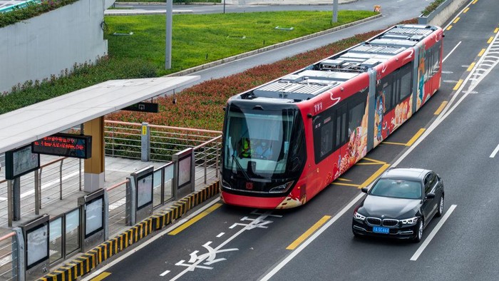 CHENGDU, CHINA - JULY 04: A red 'Shudu' train, featuring the Bashu civilization, stops at a train station on July 4, 2022 in Chengdu, Sichuan Province of China. The 30.2-meter-long smart trackless trains 'Shudu' and 'Tianfu' with a maximum capacity of 300 passengers conducted trial runs in Chengdu on Monday. The smart trackless trains have rubber tires and a small turning circle, equivalent of the turning radius of a 12-meter bus. Sichuan was known as Shu in ancient times, and Shudu means capital of Sichuan. (Photo by Liu Zhongjun/China News Service via Getty Images)