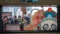 Penumpang menunggu untuk naik kereta Shudu merah. Sambil menunggu tersebut, mereka mengabadikan momen kereta 