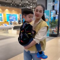 Melalui unggahan di Instagram Story miliknya, Sandra terlihat begitu menyayangi sang anak. Sambil berjalan-jalan, Sandra tampak menggendong anaknya. Foto: Instagram/@sandradewi88
