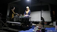 Pengunjung Green Grass menikmati malam sambil memasak di samping campervan yang menjadi lokasi singgah mereka.