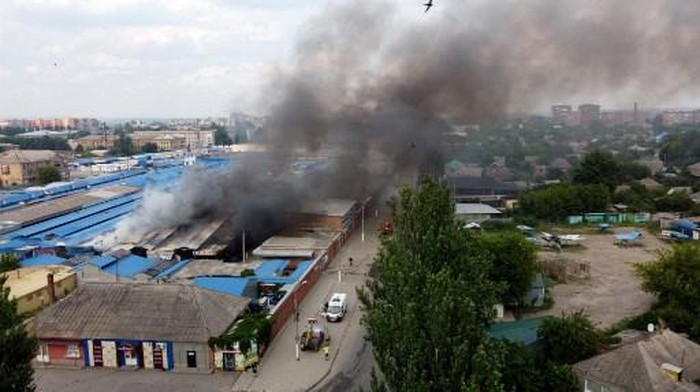 An aerial view shows smoke rising from the central market of Sloviansk, north of Kramatosk on July 5, 2022, following a suspected missile attack amid the Russian invasion of Ukraine. (Photo by MIGUEL MEDINA / AFP)