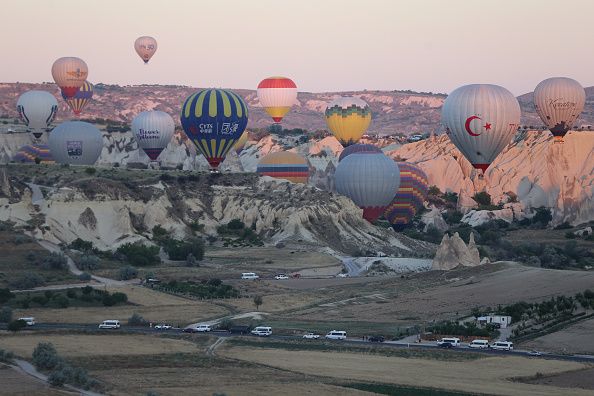 NEVSEHIR, TURKIYE - JULY 4: Hot air balloons glide over the sky at Cappadocia which attracts tourists with its historical, cultural and natural beauties in Nevsehir, Turkiye on July 4, 2022. The number of tourists flied with hot air balloons increased in the first half of this year compared to the same period last year, reaching 258,914. (Photo by Behcet Alkan/Anadolu Agency via Getty Images)