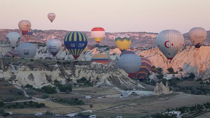 NEVSEHIR, TURKIYE - JULY 4: Hot air balloons glide over the sky at Cappadocia which attracts tourists with its historical, cultural and natural beauties in Nevsehir, Turkiye on July 4, 2022. The number of tourists flied with hot air balloons increased in the first half of this year compared to the same period last year, reaching 258,914. (Photo by Behcet Alkan/Anadolu Agency via Getty Images)