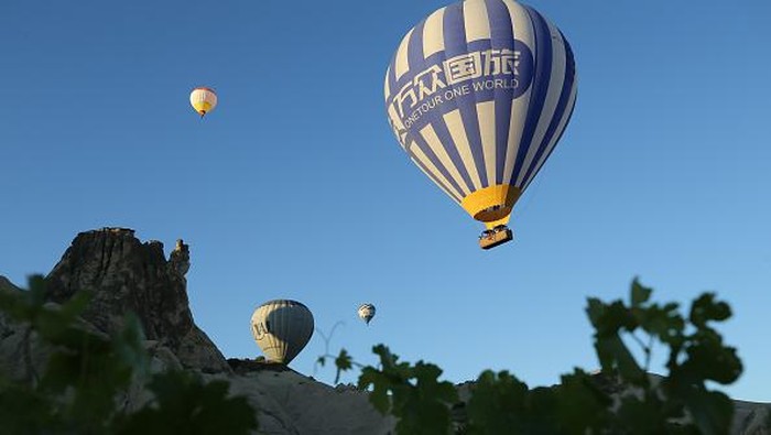 NEVSEHIR, TURKIYE - JULY 4: Hot air balloons glide over the sky at Cappadocia which attracts tourists with its historical, cultural and natural beauties in Nevsehir, Turkiye on July 4, 2022. The number of tourists flied with hot air balloons increased in the first half of this year compared to the same period last year, reaching 258,914. (Photo by Behcet Alkan/Anadolu Agency via Getty Images)