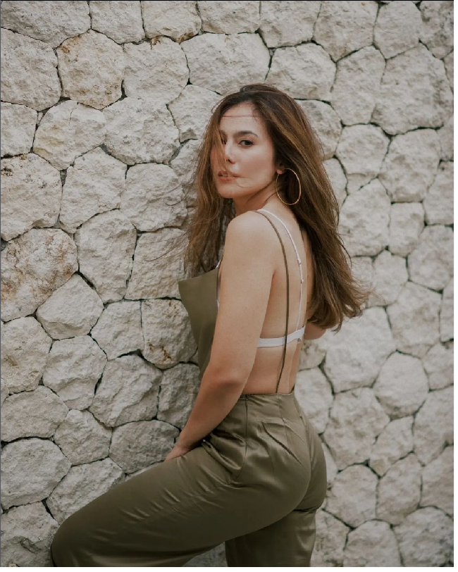 Mengenakan jumpsuit berwarna hijau tua, penampilan ibu 3 orang anak itu tak kalah memukau. Jumpsuit dengan tali spaghetti itu memliki bagian belakang yang terbuka. Model pakaiannya tu membuat bra putih yang dikenakannya terlihat jelas. Foto: Dok. Instagram wulanguritno