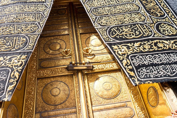 MECCA, SAUDI ARABIA: The golden doors of the Holy Kaaba closeup, covered with Kiswah. Massive lock on the doors. Entrance to the Kaaba in Masjid al Haram