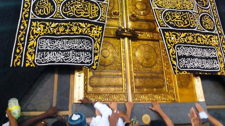 1141062011 MECCA, SAUDI ARABIA - March 2019: The golden doors of the Holy Kaaba closeup, covered with Kiswah. Massive lock on the doors. Entrance to the Kaaba in Masjid al Haram