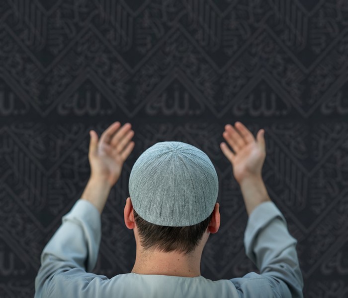Muslim pilgrims in white traditional clothes, praying at Kaaba in Makkah. High quality photo