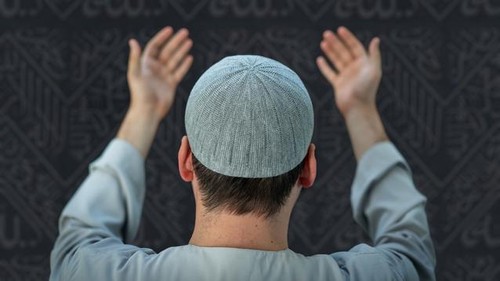 Muslim pilgrims in white traditional clothes, praying at Kaaba in Makkah. High quality photo