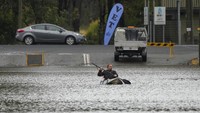 Warga mendayung perahu kayak melintasi banjir di pinggiran Kota Sydney, Selasa (5/7/2022). Lebih dari 50.000 jiwa dievakuasi dalam banjir ini.  (AP Photo/Mark Baker)