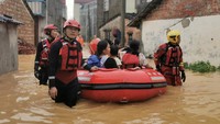 Petugas mengevakuasi warga dari banjir di anning, Guangxi, China, Selasa (5/7/2022). Banjir menggenangi sejumlah tempat di kota itu setelah badai melanda. (CFOTO/Future Publishing/Getty Images)